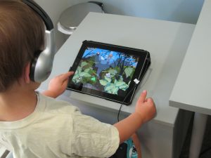 Kind traint met koptelefoon en tablet bij Acoustic Pioneer